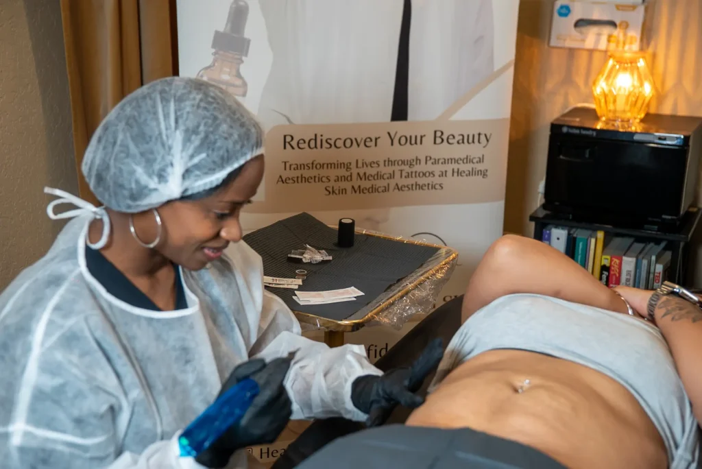 Student performing paramedical tattooing on a model near a banner promoting Healing Skin Medical Aesthetics.